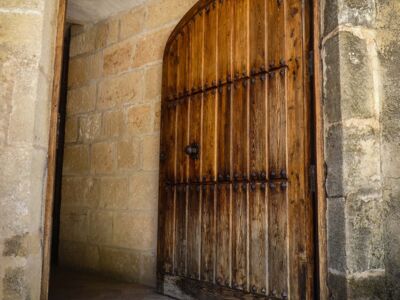 offenstehende Holztür mit Sandsteineinfassung, dahinter liegender Eingang zu einem alten Haus